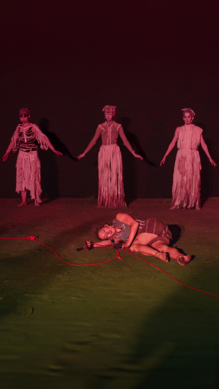 Die tote Dido (Greta Hoss) liegt auf dem Boden, im Hintergrund die drei Moiren (Corinna Storbeck, Clara Komann, Friederike Großmann).