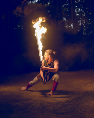 Aeneas (Gregor Lawrenz) posiert edel und kampfbereit mit Feuerschwert.