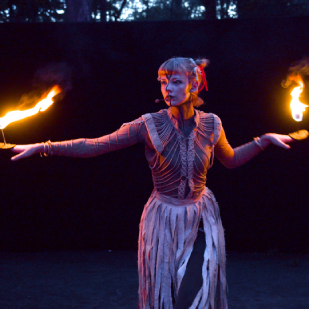 Klotho (Clara Komann), eine der drei Moiren mit Feuer in den Händen.